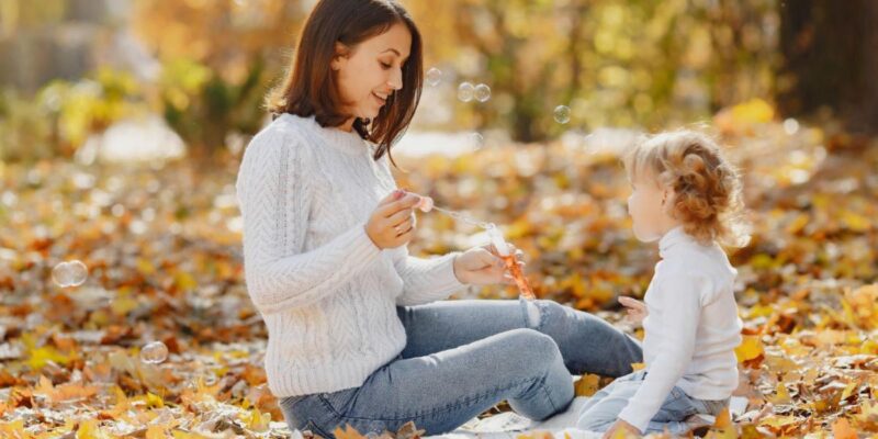 Women blowing bubbles with child